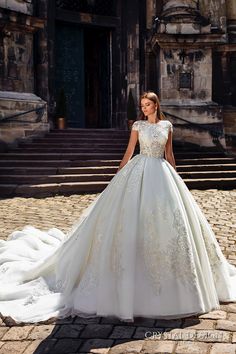 a woman in a white wedding dress standing on some steps