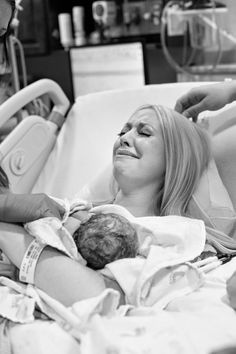 a woman laying in a hospital bed next to a man with an iv and baby