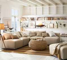 a living room filled with lots of furniture next to a large window and bookshelves