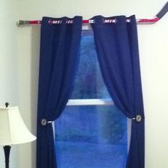 a window with blue curtains and a white lamp