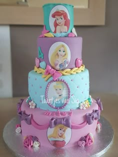 there is a three tiered cake with princesses on it