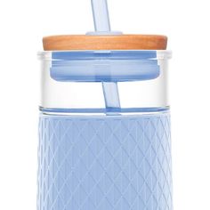 a blue glass cup with a wooden lid and straw in front of a white background