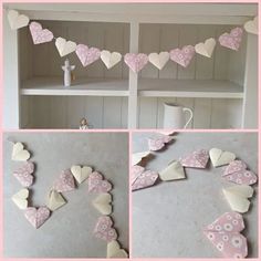 some paper hearts are hanging on the wall next to a shelf with other items in it