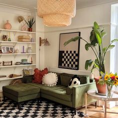 a living room filled with lots of furniture next to a large potted plant on top of a table