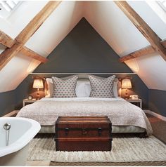 an attic bedroom with a large bed and bathtub