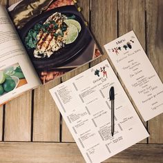 an open cookbook and menu on a wooden table