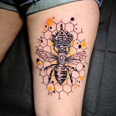 a tattoo on the leg of a woman with a bee and honeycomb