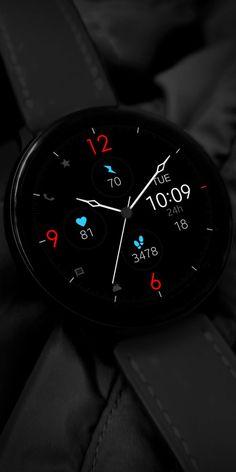 a black watch with red and blue numbers on it's face is shown in the dark