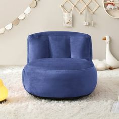 a blue chair sitting on top of a white rug in a living room next to a yellow rubber duck