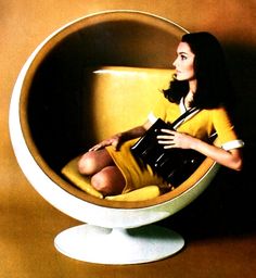 a woman sitting in a yellow chair holding a book