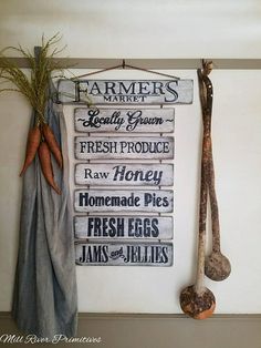 a sign hanging on the side of a wall next to carrots and other vegetables