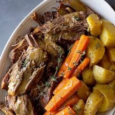 a white plate topped with meat, potatoes and carrots