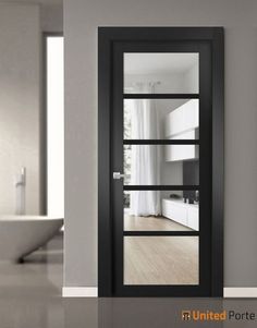 an empty room with a black door and glass panels on the doors, in front of a sink