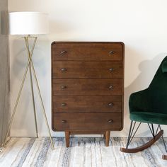 a green chair next to a wooden dresser