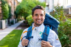 a man with a backpack is smiling for the camera