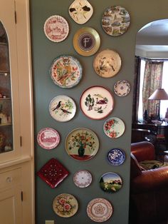 many plates are arranged on the wall in this living room