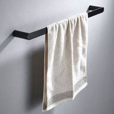 a white towel hanging on a black rail