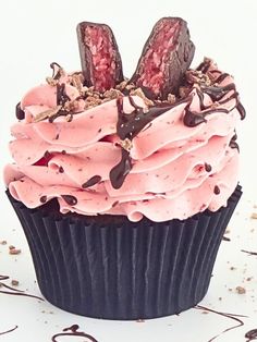 a cupcake with pink frosting and chocolate bunny ears