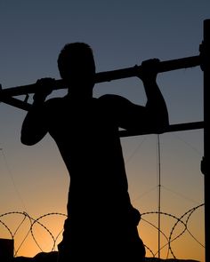 the silhouette of a man holding a baseball bat over his shoulder