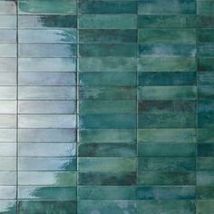 a green tiled wall with white and blue tiles on the bottom, in an abstract pattern