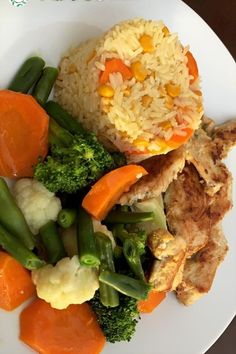 a white plate topped with rice and veggies next to meat covered in sauce