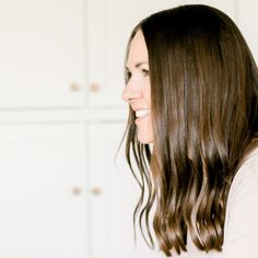 a woman with long brown hair is smiling