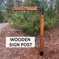 a wooden sign post sitting in the middle of a forest