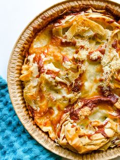 a pizza sitting in a pan on top of a blue towel