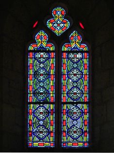 a large stained glass window in a dark room