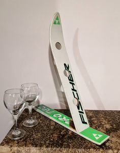 a pair of wine glasses sitting on top of a counter next to a ski board