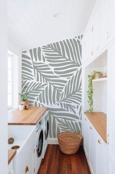 a washer and dryer in a white laundry room with wallpaper behind it