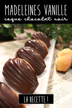 chocolate covered donuts sitting on top of a white plate next to an orange peel