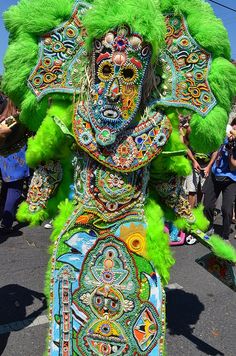 an elaborately decorated elephant is walking down the street with other people in the background