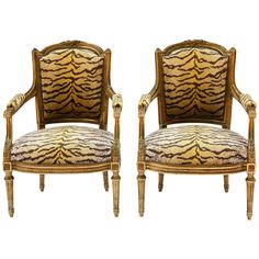 a pair of chairs with tiger print upholstered back and armrests on each side