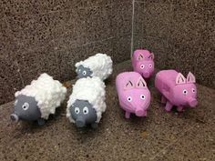 five pink and gray sheep are sitting on the ground next to each other in front of a marble wall