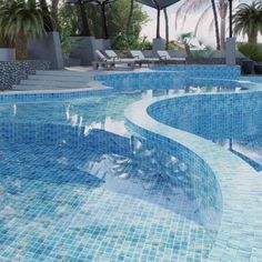 an empty swimming pool with lounge chairs and umbrellas