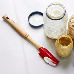 an assortment of paint and brushes sitting on a white table top next to each other