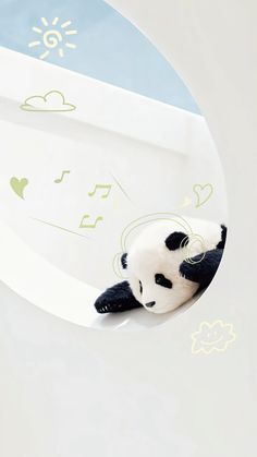 a stuffed panda bear laying on top of a white surface with musical notes painted on it