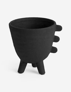 a black planter sitting on top of a white table