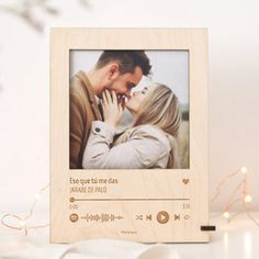 a wooden photo frame with an image of a couple kissing and the words love is in spanish