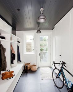 a bike is parked in front of a white door and some shelves with clothes on them