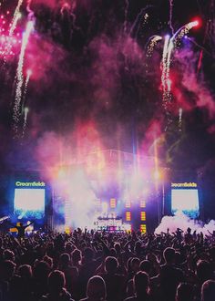 fireworks are lit up in the night sky at a concert