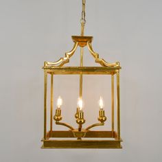 a golden chandelier with four lights hanging from it's sides and the light bulb turned on