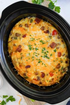 a black crock pot filled with an omelet on top of a table