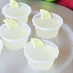 four small cups with limes on the rim