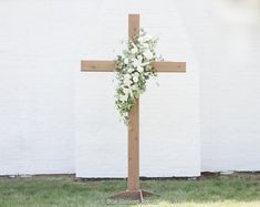 This beautiful, hand-made, cedar cross is the perfect addition for any outdoor or indoor wedding. We added beautiful white playa blanca roses, white ranunculus, ivory spray roses, ivory veronica, and sage eucalyptus, with touches of clematis draping down the sides.  The flowers shown come with the arch, unless requeste White Flowers On Cross Wedding, Rustic Cross Wedding Alter, Wedding Arch With White Roses, Floral On Cross Wedding, Wedding Cross Ceremony, Cross With White Flowers, Wedding Cross Background, Flowers On Wooden Cross Wedding, White Cross Wedding Alter