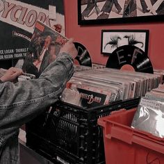 a person holding up a record in front of records