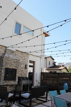 an outdoor dining area with patio furniture and string lights