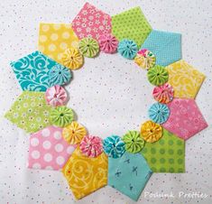 the colorful fabric is laid out on the white tablecloth with polka dots and flowers