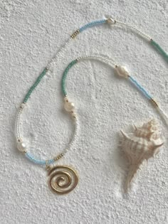 a necklace with a seashell and pearls on it